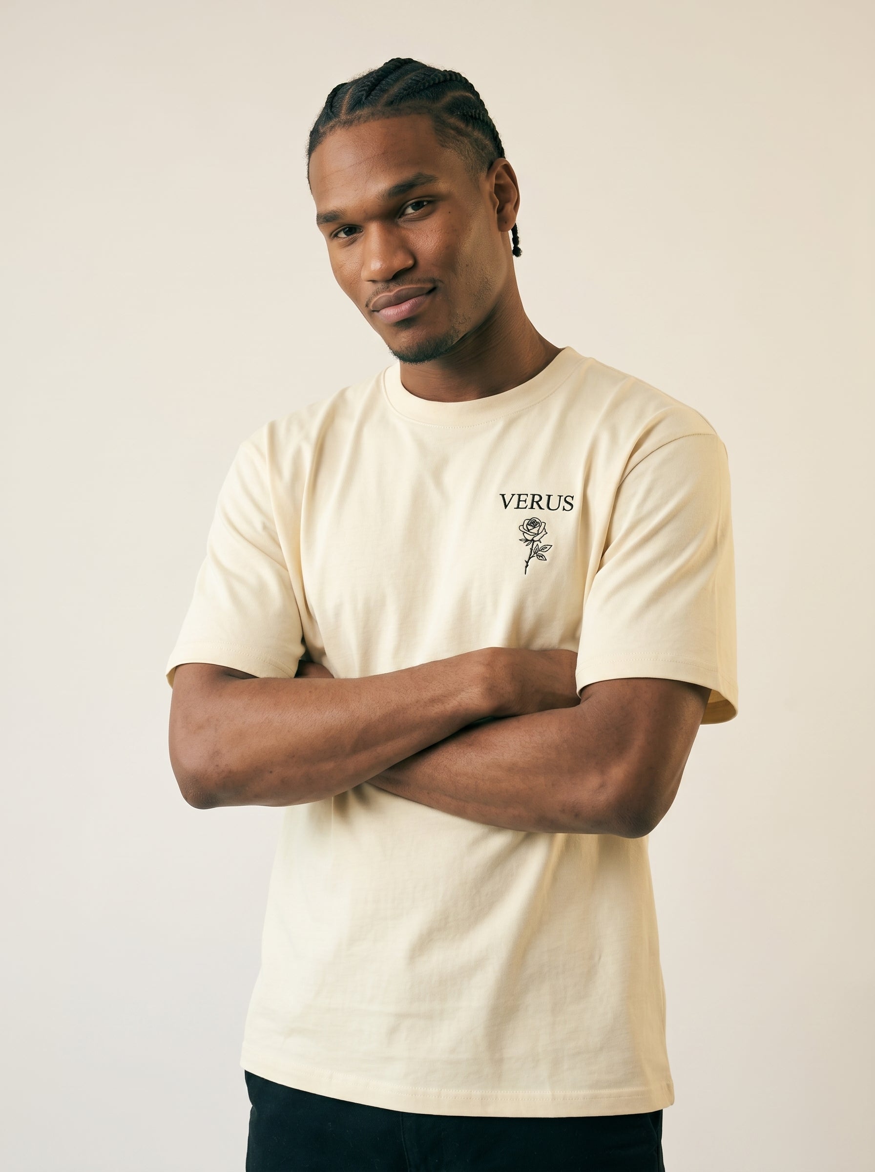 Man wearing a beige t-shirt with 'VERUS' logo on a plain background