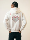 Person wearing a white hoodie with a red heart design on the back against a plain background