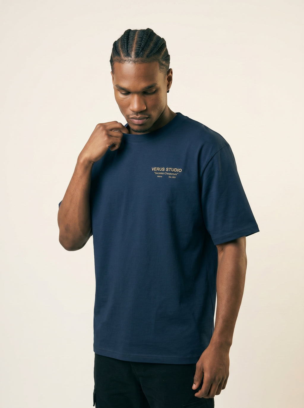Man wearing a navy blue t-shirt with a logo on a beige background