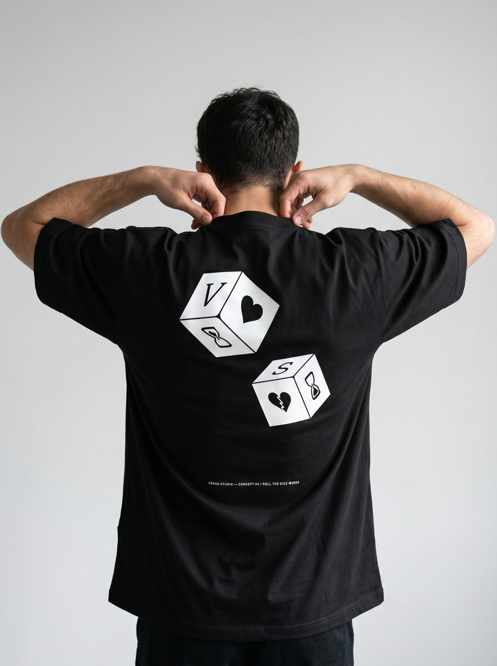 Person wearing a black t-shirt with white graphic designs on the back against a gray background