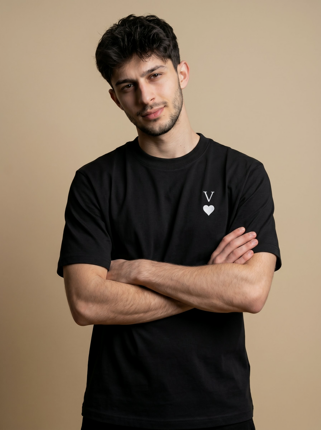 Man wearing a black t-shirt with a heart logo on a beige background