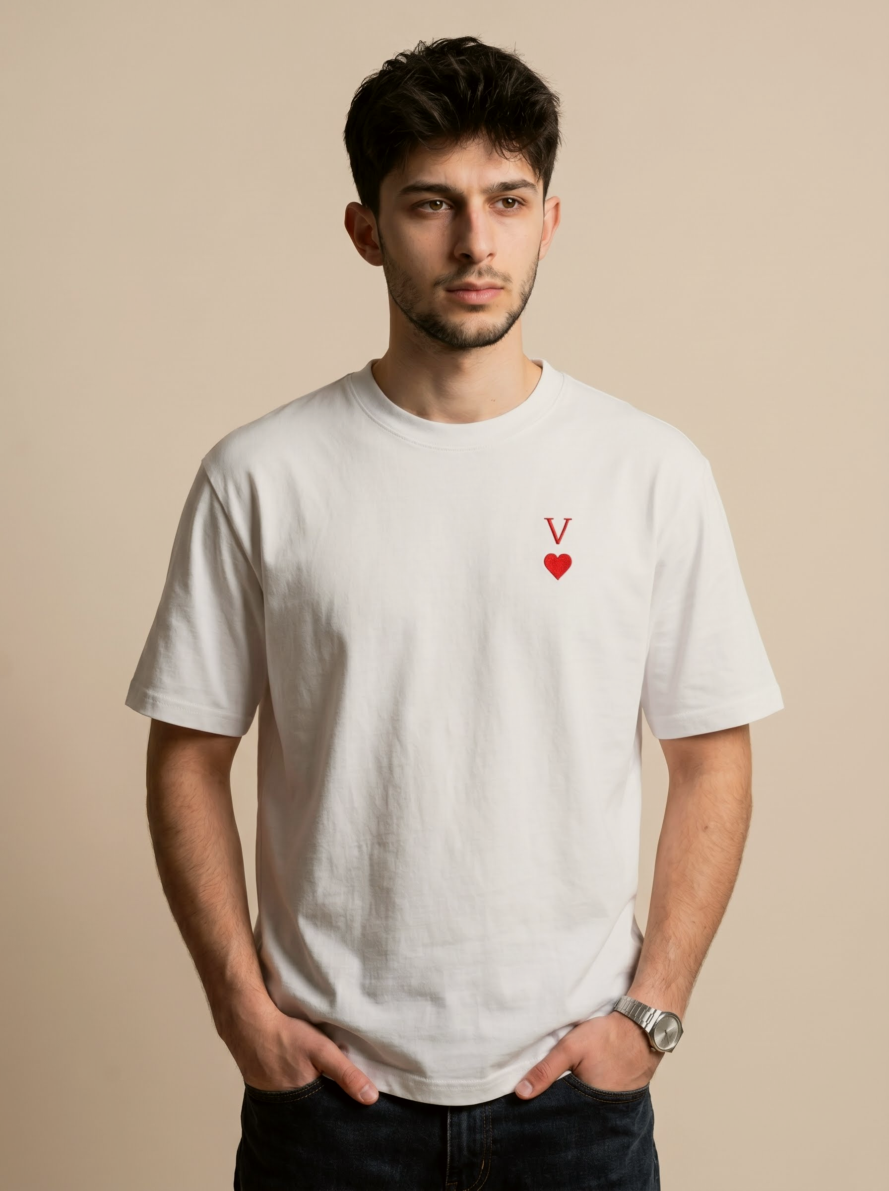 Man wearing a white t-shirt with a red heart and letter 'V' design on a beige background