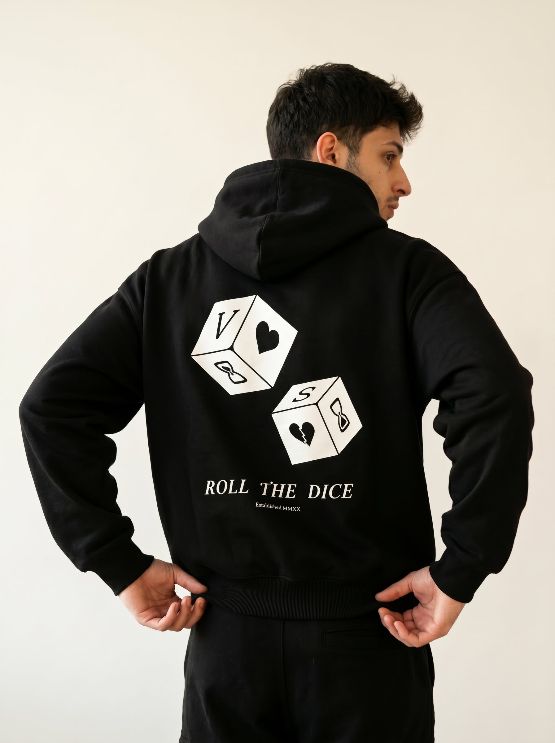 Person wearing a black hoodie with dice design and text on the back