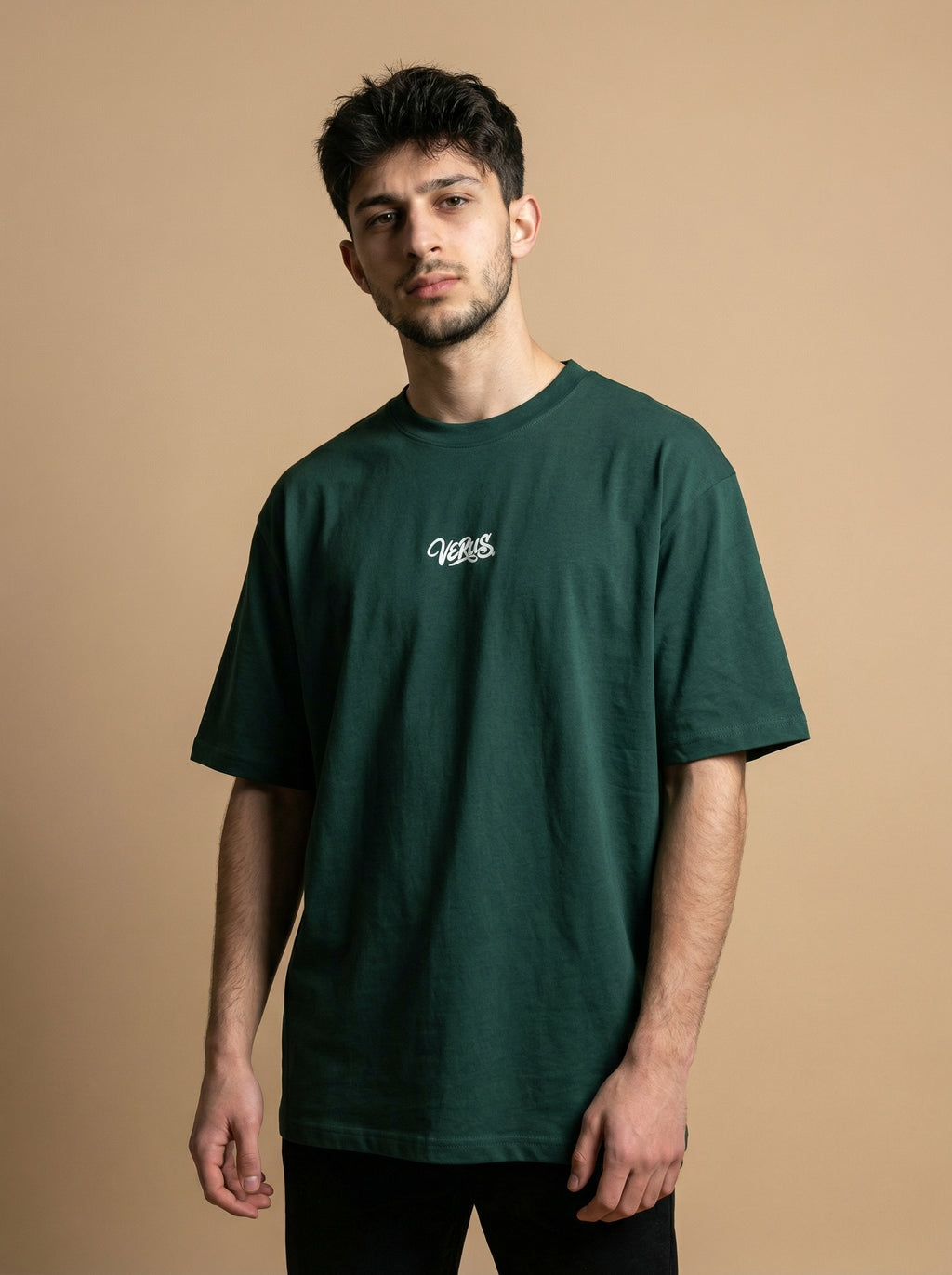 Man wearing a green t-shirt with a logo on a beige background