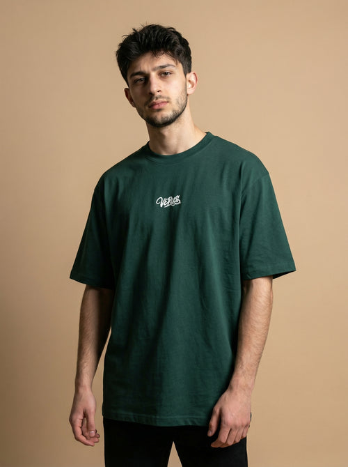 Man wearing a green t-shirt with a logo on a beige background