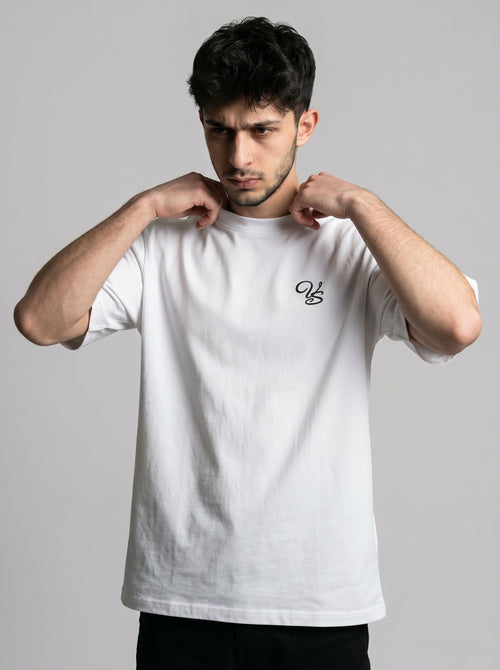 Man wearing a white t-shirt with a small logo on a gray background