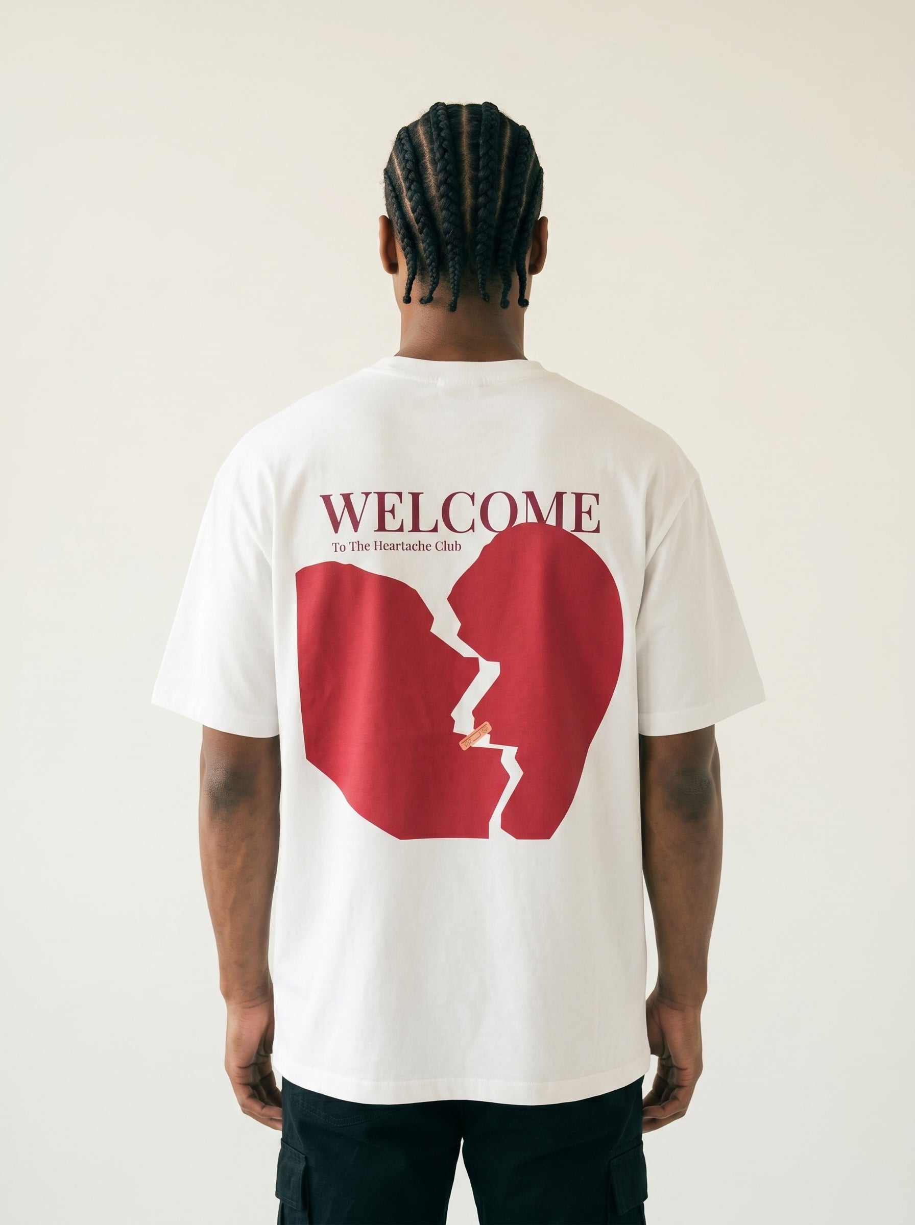 Person wearing a white t-shirt with a red graphic and 'WELCOME' text on the back.
