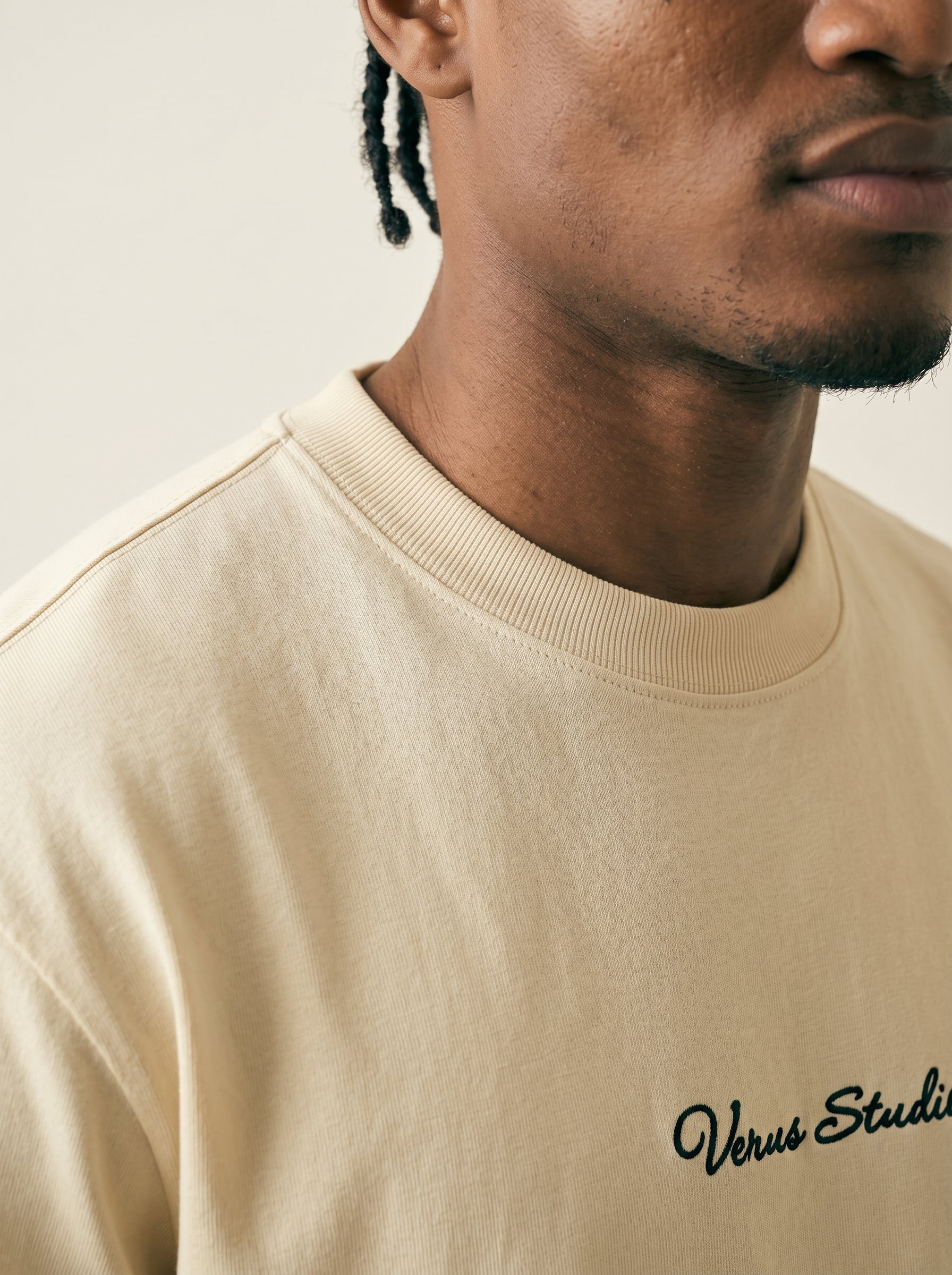 Beige sweatshirt with 'Versus Studio' text worn by a person
