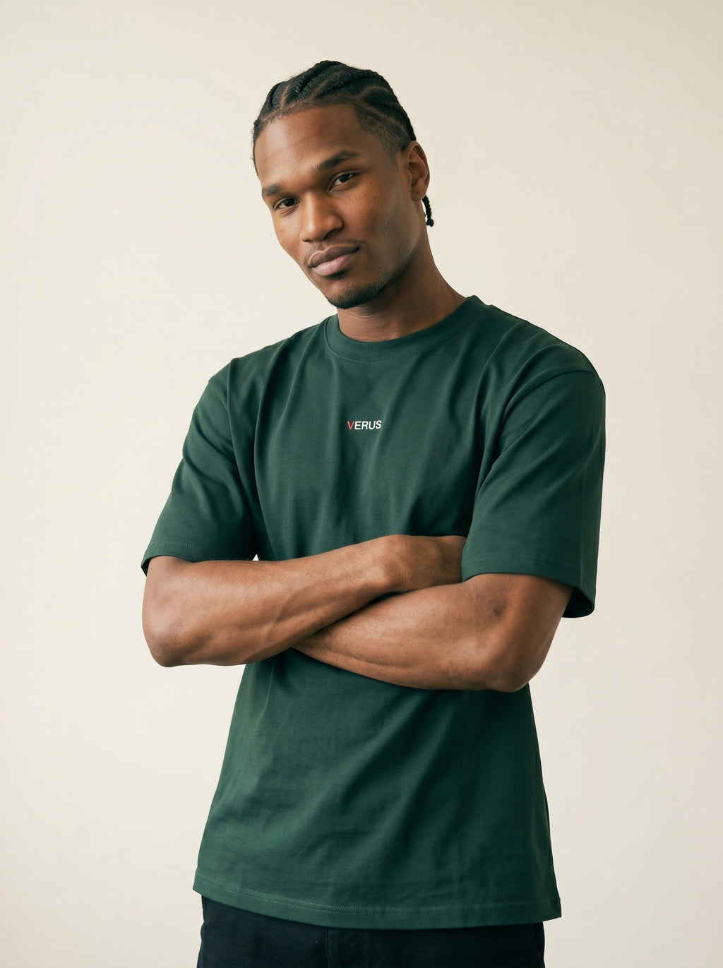 Man wearing a green t-shirt with a brand logo on a beige background