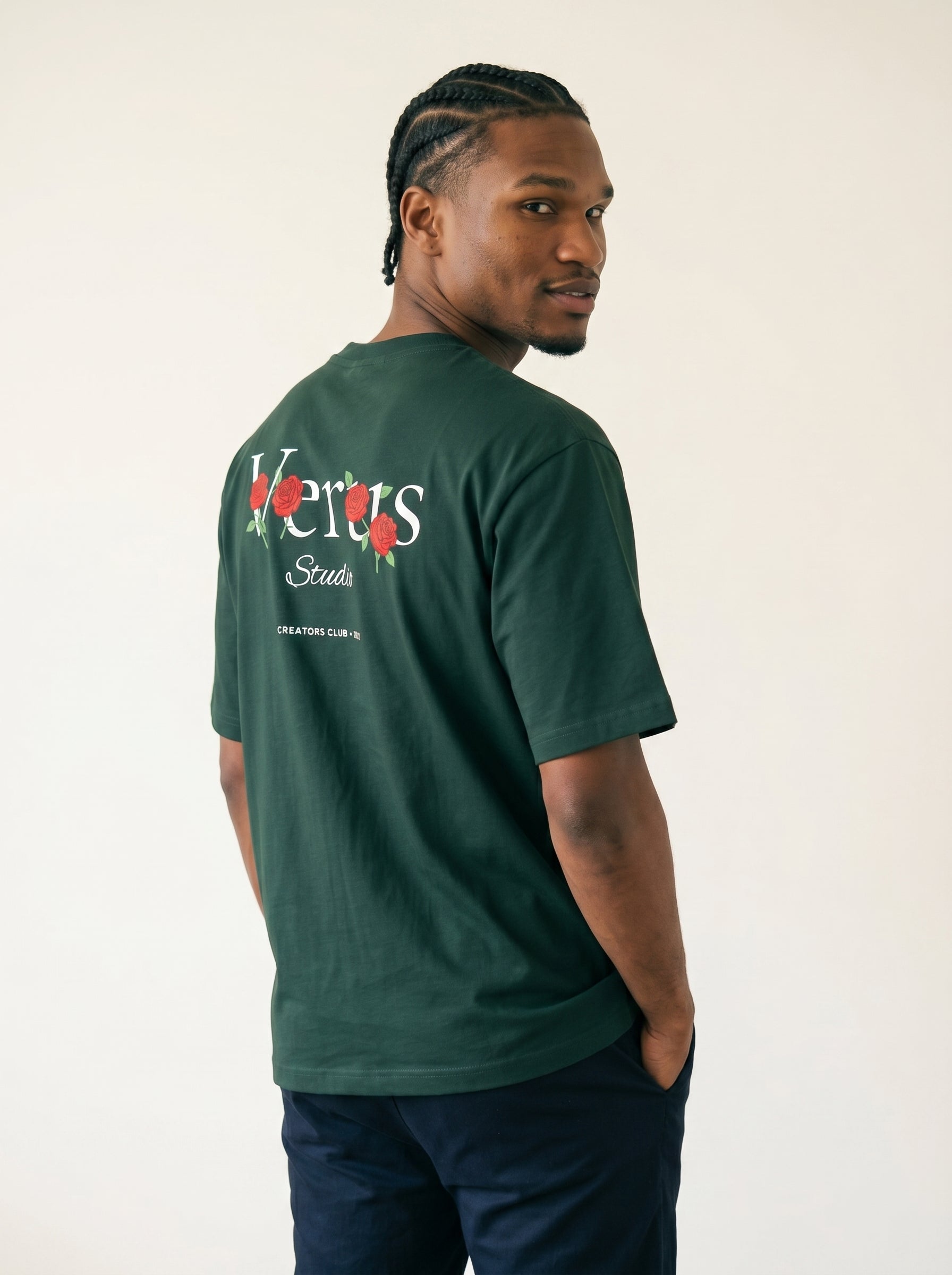 Man wearing a green t-shirt with branding on the back against a plain background