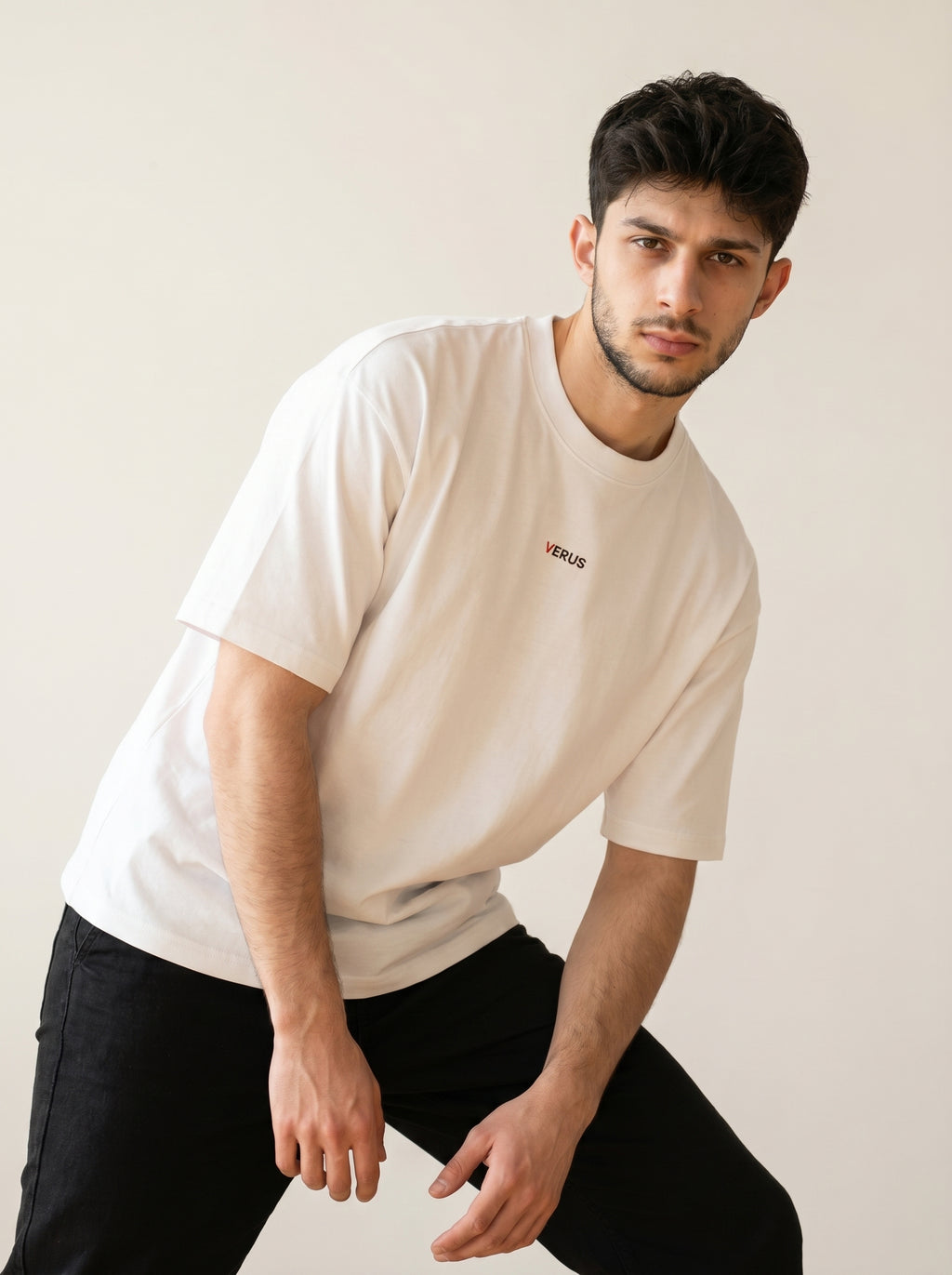 Man wearing a white t-shirt with a logo on a plain background