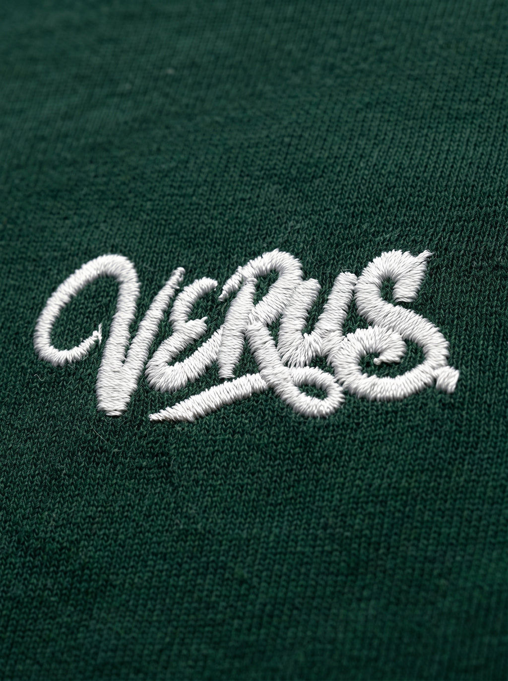 Embroidered logo on a green fabric background