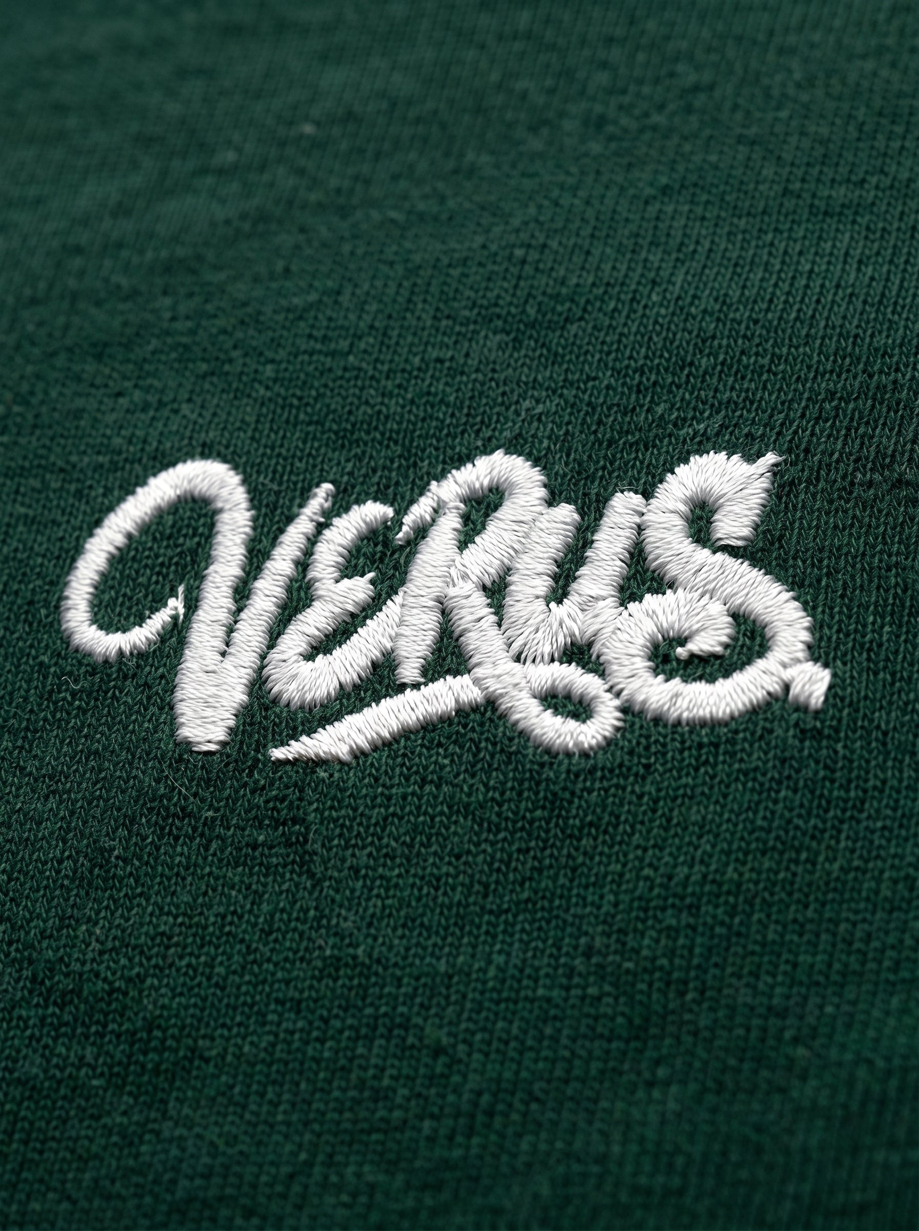 Embroidered logo on a green fabric background